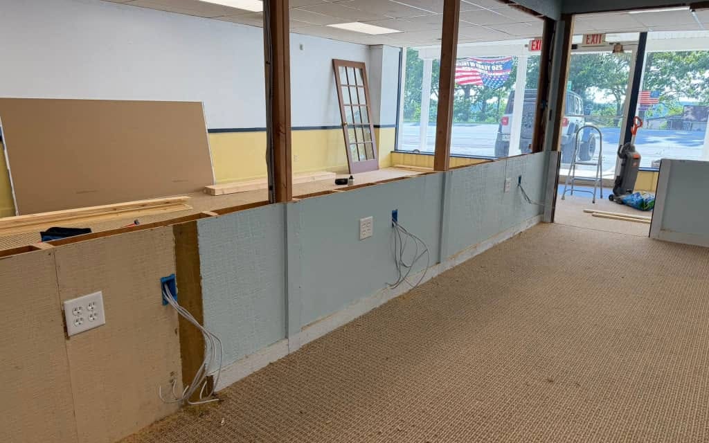 Network cables pulled to new outlet boxes along a half-built office partition