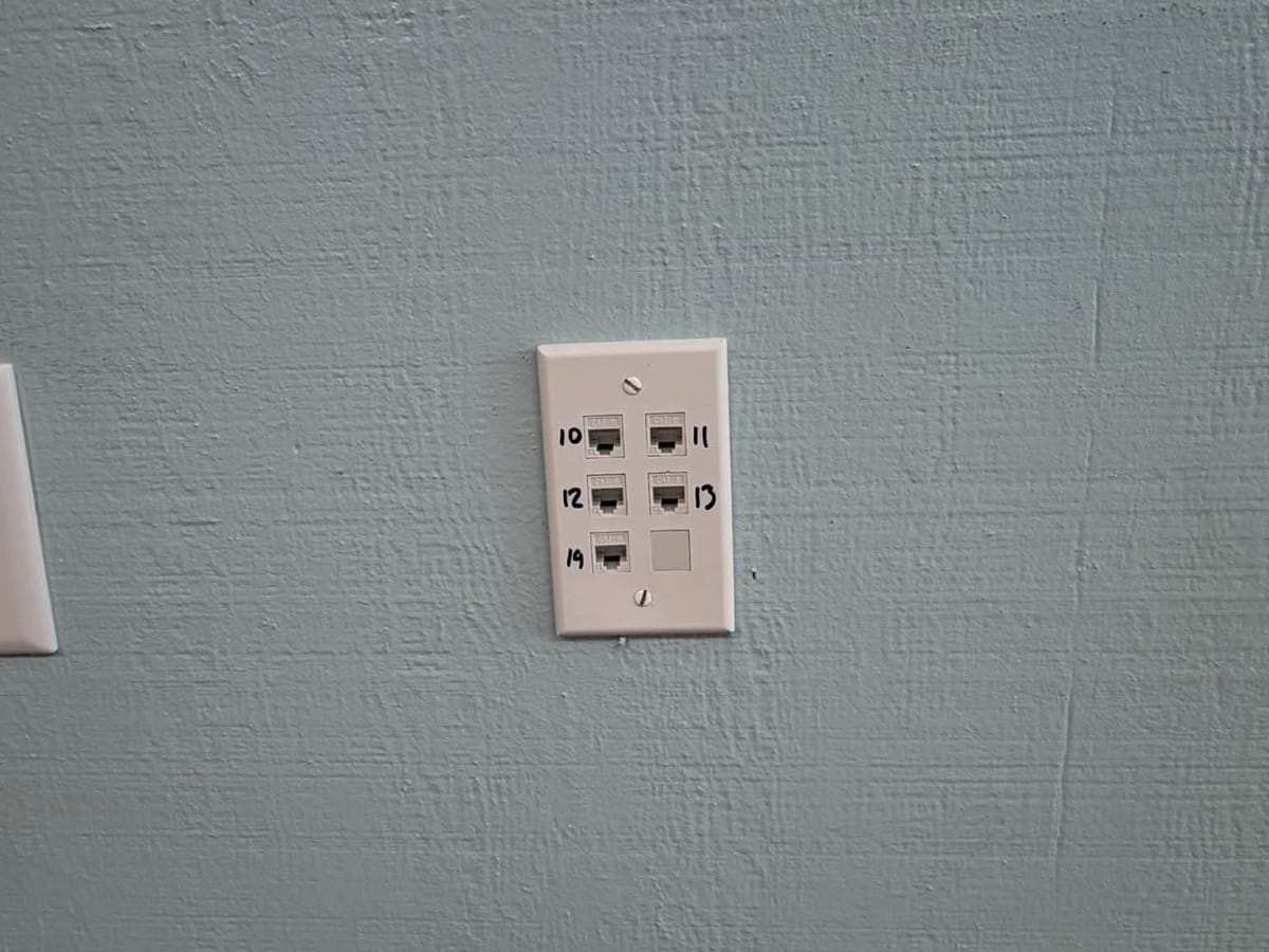 A wall plate with five numbered network ports