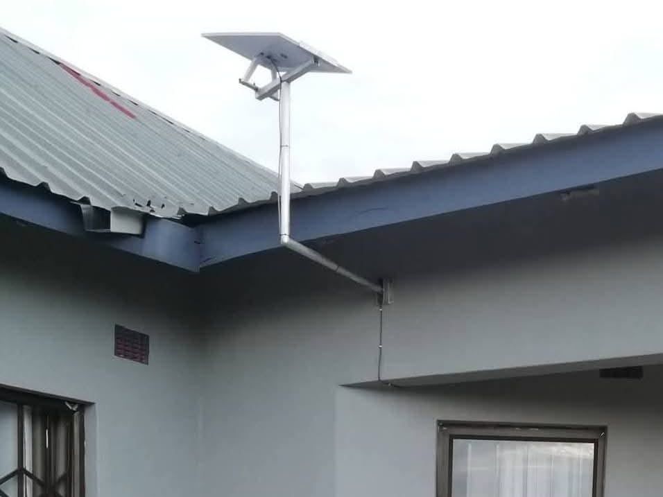 A Starlink dish mounted above the roof of a house