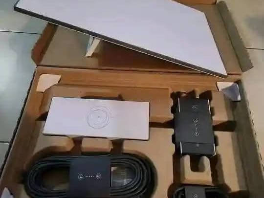 A Starlink kit in its box: dish, router, cable and power supply